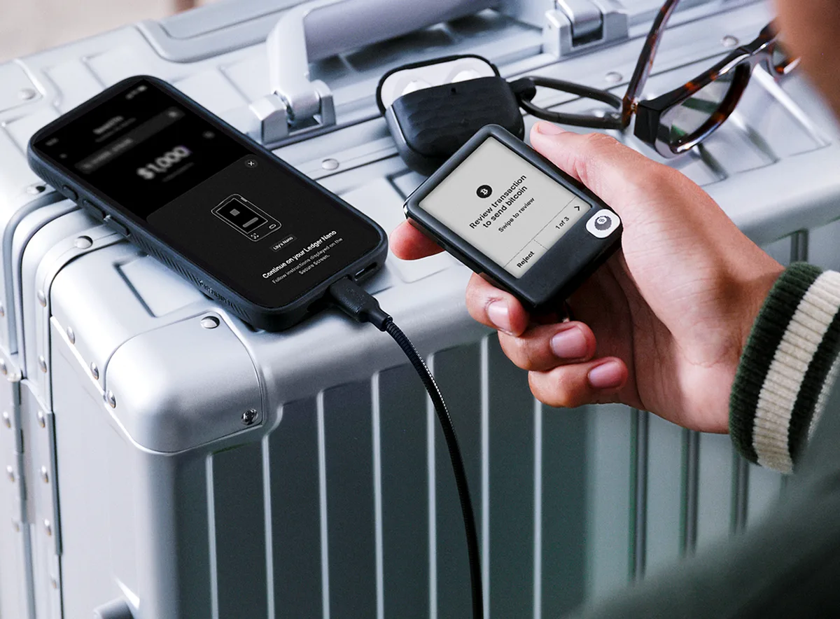 Appareil Ledger connecté par câble avec une confirmation affichée sur son écran